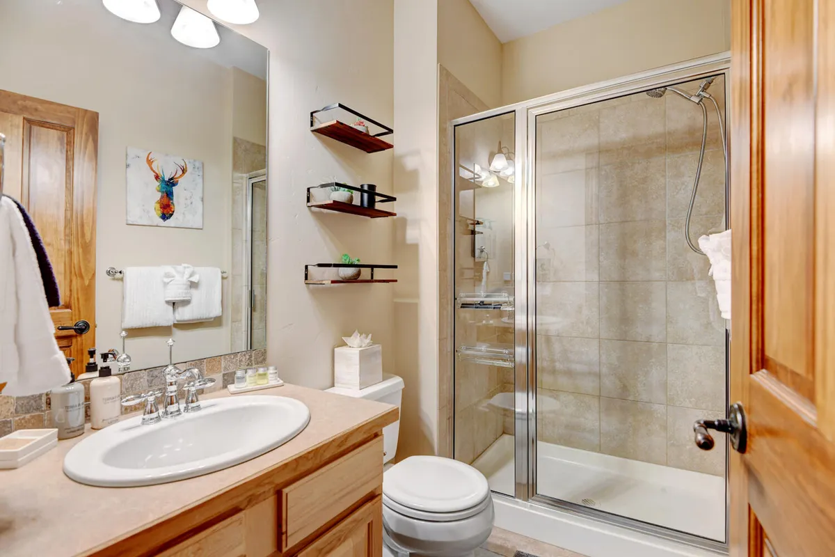A spa-like bathroom featuring a modern shower area, stylish vanity, and decorative wall art. The clean decor and functional features make the space inviting for relaxation and self-care.